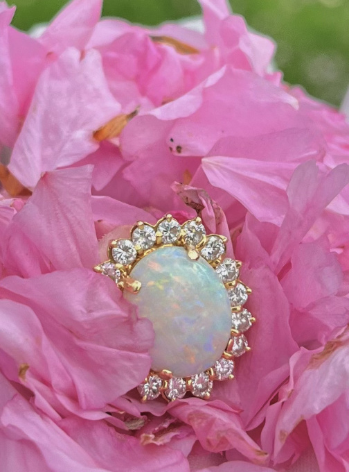 Yellow gold ring with white opal and diamond halo by Artista Sconosciuto