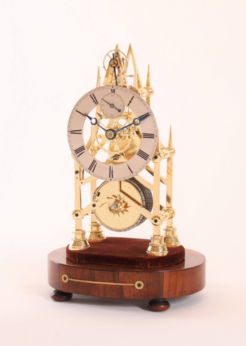 A small English brass skeleton clock with balance wheel, circa 1840 by Onbekende Kunstenaar